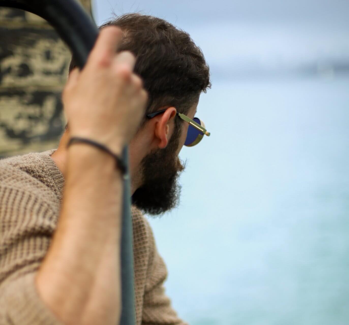 Man with beard looking out to sea